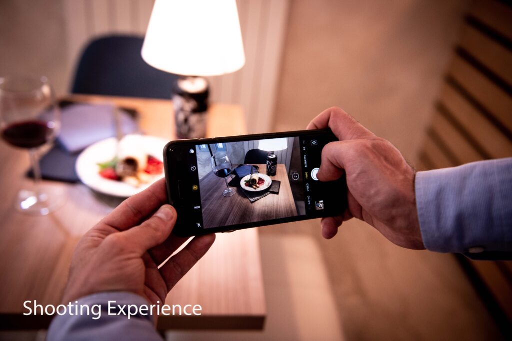Esperienza fotografica hotel – ospite che fotografa con smartphone un piatto gourmet al ristorante